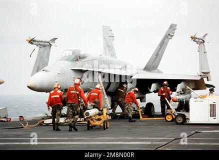 Aviation Ordnancemen from Marine Fighter Attack Squadron 251 (VMFA-251) carica missili su un F/A-18C Hornet a bordo della portaerei USS GEORGE WASHINGTON (CVN 73). George Washington e VMFA-251 sono schierati nel Golfo Persico a sostegno dell'operazione Southern Watch. Soggetto operativo/Serie: SOUTHERN WATCH base: USS George Washington (CVN 73) Paese: At Sea Foto Stock