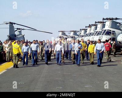 I marinai DELLA Marina STATUNITENSE e i Marines statunitensi a bordo della nave d'assalto anfibio USS GUAM (LPH 9) camminano lungo il ponte di volo alla ricerca di detriti di oggetti estranei (Foreign Object Drouts, FOD). GUAM viene schierato nel Golfo Persico a sostegno dell'operazione SOUTHERN WATCH, 15 febbraio 1998. Funzionamento/Serie del soggetto: BASE OROLOGIO SOUTHERN: USS Guam (LPH 9) Foto Stock