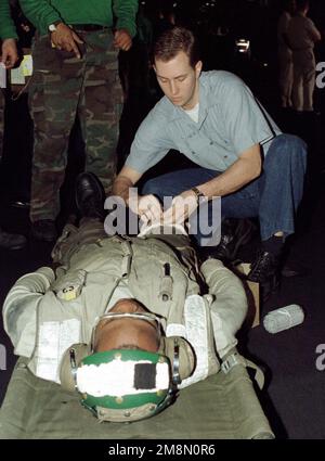 US Navy Hospital Corpsman 3rd Classe (hm3) Shane Latimer applica una fasciatura alla gamba di un membro dell'equipaggio ferito durante un esercizio di addestramento di massa a bordo della portaerei convenzionale USS INDEPENDENCE (CV 62). L'INDIPENDENZA e il vettore è imbarcato Air Wing Five (CVW-5) sono schierati in avanti nel Golfo Persico per applicare le sanzioni ONU contro l'Iraq. Operazione orologio SOUTHRN, 21 febbraio 1998. Operazione/Serie oggetto: SOUTHERN WATCH base: USS Independence (CV 62) Foto Stock