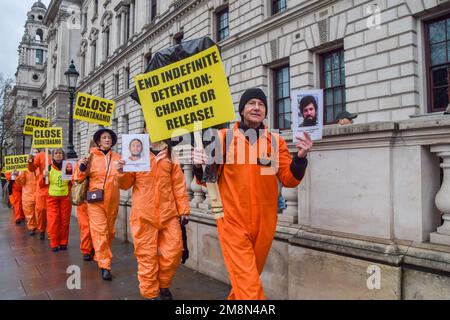 Londra, Regno Unito. 14th Jan, 2023. Durante la manifestazione in Piazza del Parlamento, i manifestanti tengono cartelli anti-Guantánamo e foto dei prigionieri di Guantánamo. Gli attivisti che indossavano tute di prigione arancioni hanno marciato attraverso Westminster chiedendo la chiusura del campo di detenzione di Guantánamo Bay. Il 11th gennaio ha segnato il 21st° anniversario dall'apertura della controversa prigione. Credit: SOPA Images Limited/Alamy Live News Foto Stock