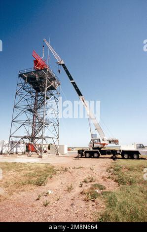 Una grande gru azionata da un appaltatore civile viene utilizzata per rimuovere l'antenna del sistema di segnalazione radar del controllo del traffico aereo dalla cima della torre del radar di sorveglianza aeroportuale (ASR) ad Altus AFB, Oklahoma. Lo squadrone di comunicazione 97th sta sostituendo il piedistallo e l'antenna ARS nella parte superiore della torre. Base: Altus Air Force base Stato: Oklahoma (OK) Paese: Stati Uniti d'America (USA) Foto Stock