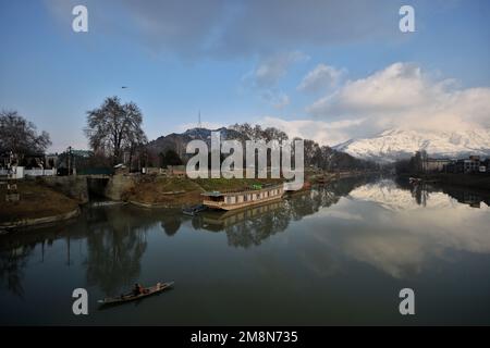 14 gennaio 2023, Srinagar, Jammu e Kashmir, India: Vista del fiume Jhelum e neve coperta colline Zabarwan durante una giornata di sole dopo la fresca nevicata a Srinagar. L'ufficio meteo ha previsioni meteo a Kashmir fino al 14-18 gennaio. (Credit Image: © MUbashir Hassan/Pacific Press via ZUMA Press Wire) SOLO PER USO EDITORIALE! Non per USO commerciale! Credit: ZUMA Press, Inc./Alamy Live News Foto Stock