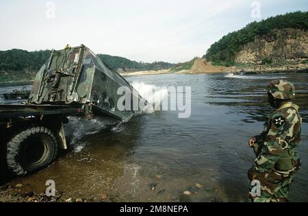 Un soldato assegnato alla 50th Engineer Company, 1st Platoon, Camp Laguardia, Repubblica di Corea (ROK), guarda su come una sezione ponte di pontone scaricato da un trasportatore ponte M945, spruzza nel fiume Imjin, ROK, durante un esercizio di addestramento di costruzione di ponte il 22 ottobre 1998. Molti dei partecipanti all'esercitazione odierna sono ufficiali che partecipano in conformità con il programma di sviluppo professionale dell'ufficiale dell'esercito degli Stati Uniti, un programma progettato per migliorare la costruzione della squadra e soldiery.Aeased). Subject Operation/Series: COREA CD base: Imjin River Nazione: Repubblica di Corea (KOR) Foto Stock