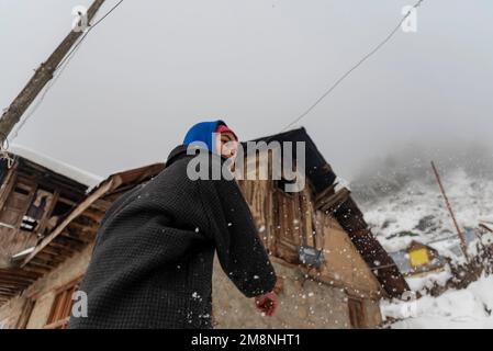 Srinagar, India. 15th Jan, 2023. Un bambino cammina attraverso la neve come giocano dopo una nevicata pesante nella periferia di Srinagar. A causa delle forti nevicate, ci sono state valanghe multiple in diversi luoghi del Kashmir. Il periodo di 40 giorni dal 21 dicembre al 31st gennaio, noto anche come Chilai Kalan, in Kashmir è considerato il più cruciale quando nevica la condizione peggiora ulteriormente. Credit: SOPA Images Limited/Alamy Live News Foto Stock