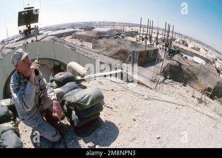 Visto dalla cima di un bunker presso la base aerea di Ali al Salem, soprannominata la 'Rock', il confine iracheno incombe in lontananza dietro L'ANZIANO AIRMAN Larry Six. La roccia ospita il 9th Air Expeditionary Group, composto da oltre 1500 persone, e si trova a soli 39 km dal confine con l'Iraq. Questa foto fa parte della storia "on the Borderline" nel luglio 1999, AIRMAN Magazine. L'articolo descrive la vita al 'Rock' e come la sua missione e il suo personale sono aumentati dalla fine della guerra del Golfo Persico sotto l'operazione Southern Watch. Soggetto operazione/Serie: OPERAZIONE BASE DI OROLOGIO MERIDIONALE: Ali al Salem Air base Cou Foto Stock
