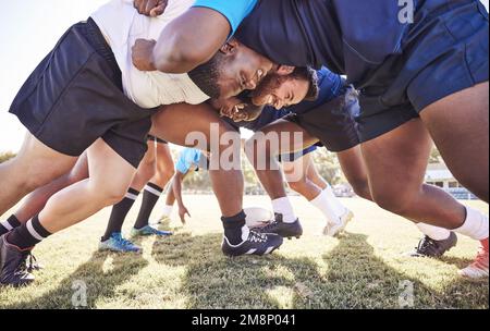 Al di sotto di due squadre di rugby avversari che lottano una mischia durante una partita fuori su un campo. I giocatori di Rugby combattono e combattono per vincere la palla mentre Foto Stock