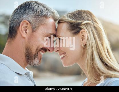 Felice e amorevole coppia matura caucasica godendo di una romantica data in spiaggia insieme in una giornata di sole. Allegro affettuoso marito e moglie Foto Stock