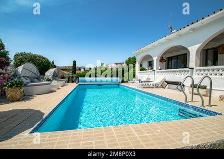 Un'immagine di uno chalet mediterraneo con una piscina in giardino Foto Stock