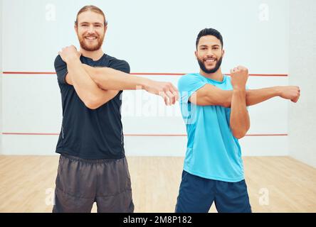 Ritratto di due giocatori di squash che si allungano e sorridono prima di giocare a gioco di campo. Felice fit caucasico e misto atleta di corsa in piedi insieme e. Foto Stock