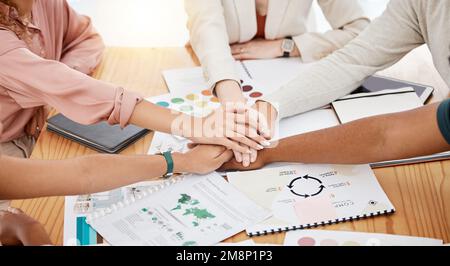 Gruppo di uomini d'affari che hanno una riunione ad un tavolo in un ufficio. I professionisti del settore si uniscono per sostenere il lavoro. Impilamento dei dipendenti Foto Stock