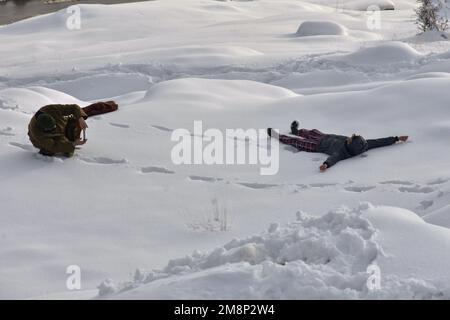 Srinagar, India. 14th Jan, 2023. I visitatori scattano foto sulla collina innevata dopo una fresca nevicata alla periferia di Srinagar. Il tempo è migliorato nella valle del Kashmir dopo giorni di nevicate e piogge da moderate a pesanti. Nel frattempo, gli valanghe sono stati segnalati il sabato nel distretto di Bandipora e nella stazione di Sonamerg Hill che hanno assistito a nevicate da moderate a pesanti negli ultimi giorni. Questo è il secondo incidente riportato nella popolare stazione collinare negli ultimi due giorni. Due operai sono morti giovedì quando una valanga ha colpito il sito di lavoro di un'impresa di costruzione a Sonamerg. Credit: IMMAGINE DI SOPA Foto Stock