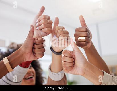 Gruppo eterogeneo di donne di affari etniche sconosciute che mostrano pollici con gesto di mano dopo la riunione in carica. Team professionale ambizioso e sicuro di Foto Stock