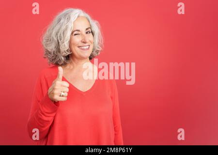 Donna che strinca come lei dà un pollice in su in approvazione Foto Stock