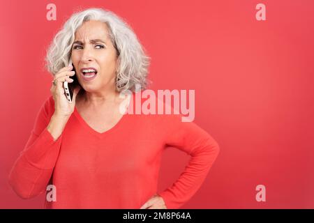 Donna che cerca di sentire ciò che dice sul cellulare Foto Stock