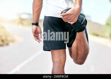 Il giovane uomo da corsa misto che si stende prima del suo esercizio all'aperto. Primo piano maschio riscaldamento e prepararsi per una corsa o jogging Foto Stock