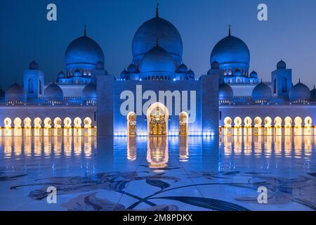 Vista ravvicinata simmetrica durante l'ora blu della maestosa moschea dello sceicco Zayed ad Abu Dhabi Foto Stock