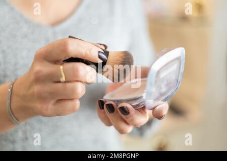 Primo piano delle mani di una donna anziana che gestiscono gli oggetti per il trucco. Foto Stock