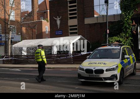 Polizia sulla scena di una sparatoria fuori di un servizio commemorativo che si teneva nella chiesa cattolica romana di San Aloysius su Phoenix Road, a Euston, alle 1,30pm circa del sabato. Una ragazza di sette anni è in una condizione di pericolo di vita a seguito del sospetto drive-by sparando fuori dalla chiesa, mentre un'altra ragazza e quattro donne sono state ferite nello stesso incidente. Data immagine: Domenica 15 gennaio 2023. Foto Stock