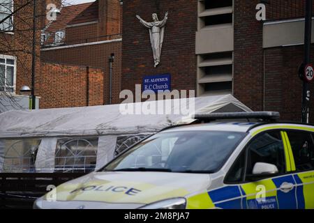 Polizia sulla scena di una sparatoria fuori di un servizio commemorativo che si teneva nella chiesa cattolica romana di San Aloysius su Phoenix Road, a Euston, alle 1,30pm circa del sabato. Una bambina di sette anni si trova in una condizione stabile ma pericolosa per la vita a seguito del sospetto tiro al piattello fuori della chiesa, mentre un'altra ragazza e quattro donne sono state ferite nello stesso incidente. Data immagine: Domenica 15 gennaio 2023. Foto Stock