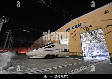 Urumqi, Cina. 14th Jan, 2023. (230115) -- URUMQI, 15 gennaio 2023 (Xinhua) -- Un treno ad alta velocità tira fuori da un centro di manutenzione in Urumqi, regione autonoma di Xinjiang Uygur della Cina nord-occidentale, 14 gennaio 2023. I tecnici di un centro di manutenzione dei treni ad alta velocità di Urumqi sono stati impegnati a eseguire lavori di manutenzione dei treni durante la corsa di corsa del Festival di Primavera. La corsa al Festival di Primavera, conosciuta anche come 'chunyun', è iniziata il 7 gennaio e durerà fino al 15 febbraio di quest'anno, durante il quale molti cinesi si reuniranno con le loro famiglie per il Capodanno lunare cinese, che cade su J Foto Stock