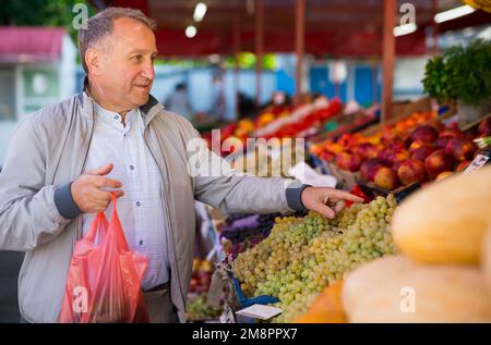 Uomo di mezza età che acquista frutti Foto Stock