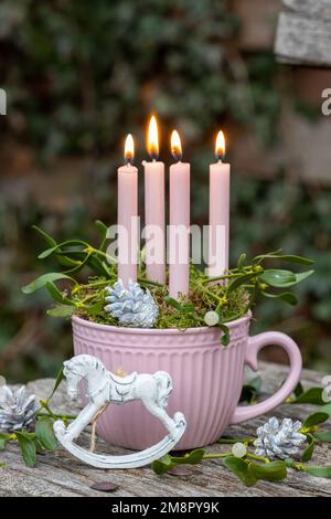 decorazione natalizia con cavallo a dondolo, candele e rami di mistletoe Foto Stock