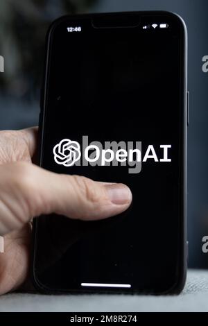 Mano da donna che tiene un iPhone con il logo OpenAI. ChatGPT e Chat bot cultura, intelligenza artificiale tempo. 01.01.2023 Amsterdam, Paesi Bassi Foto Stock