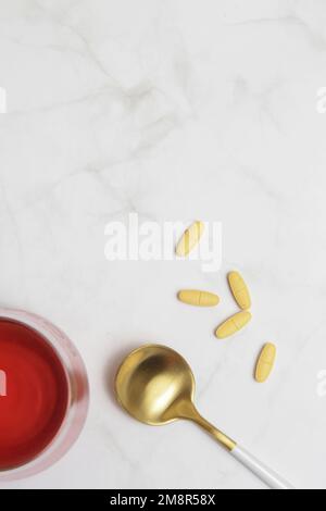 Additivi alimentari eccellenti. Polvere di proteina del collagene, pillole, cucchiaio e bicchiere d'acqua. Supplemento collagene per pelle, articolazioni e budella. Foto Stock