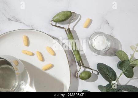 Diversi tipi di prodotti di bellezza, viso rullo, collagene, vitamine, idratante. Articoli anti-età per la cura della pelle, vista dall'alto. Foto Stock