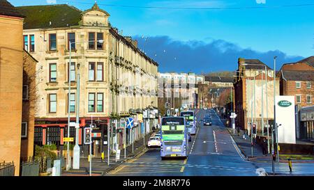 Glasgow, Scozia, Regno Unito 15th gennaio 2023. UK Weather: Bus elettrico senza carbonio bagnato e ventoso ha visto strade umide miserabili come è uscito questa settimana l'aspettativa di vita per la gente del posto è stata la più bassa nel regno unito a 74. Maryhill Road un punto focale della privazione urbana e del crimine vede enormi quantità di traffico. Credit Gerard Ferry/Alamy Live News Foto Stock