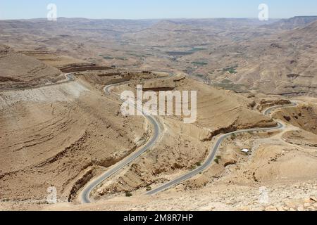 Jordan - strada desertica tortuosa della Kings Highway che scende nel canyon di Wadi Mujib Foto Stock