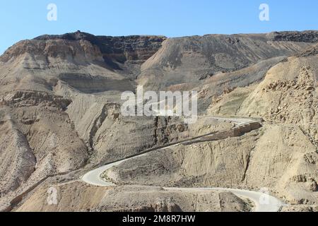 Jordan - strada desertica tortuosa della Kings Highway che scende nel canyon di Wadi Mujib Foto Stock