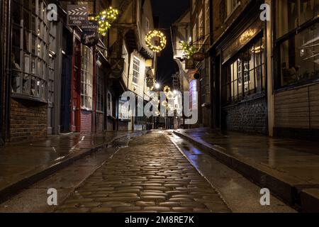 The Shambles, storica strada medievale di York a Natale con strada acciottolata bagnata Foto Stock