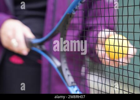 donna con racchetta da tennis e palla. Donna nello sport. Selezione della messa a fuoco Foto Stock