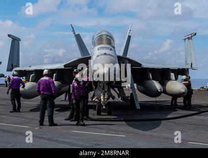 Mar Cinese Meridionale, acque internazionali. 14th Jan, 2023. Mar Cinese Meridionale, acque internazionali. 14 gennaio 2023. NEGLI STATI UNITI L'ufficiale di sicurezza del ponte di volo della Marina dirige un aereo da combattimento F/A-18F Super Hornet, con i Fighting Redcks of Strike Fighter Squadron 22 che lanciano dal ponte di volo della portaerei di classe Nimitz USS Nimitz, 14 gennaio 2023 operante nel Mar Cinese Meridionale. Credit: MC3 Joseph Calabrese/US Navy/Alamy Live News Foto Stock