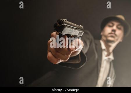 gangster della vecchia scuola con la pistola in mano Foto Stock