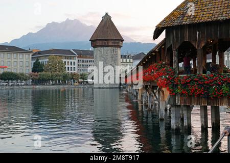 Ponte della Cappella (Kapelbrücke) e Water Tower sul fiume Reuss, Lucerna, Svizzera con il Monte Pilatus sullo sfondo Foto Stock