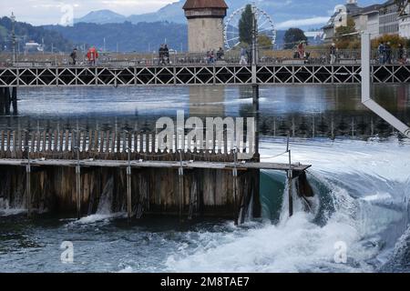 Ponte della Cappella (Kapelbrücke) e Water Tower sul fiume Reuss, Lucerna, Svizzera con il Monte Pilatus sullo sfondo e lo sbarramento in primo piano Foto Stock
