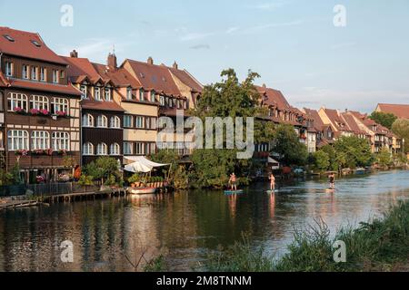 Vista del quartiere storico sulla riva del fiume Regnitz Bamberg con persone in piedi paddle board. Foto Stock