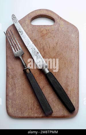 altes Hilzschneidebrett mit Besteck Foto Stock
