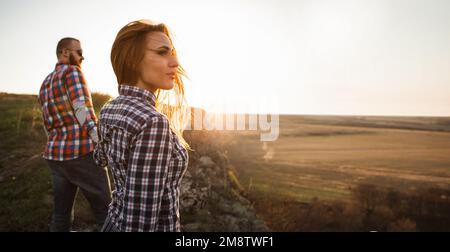 Uomo e donna in montagna al tramonto. Coppia amorevole felice. Foto Stock