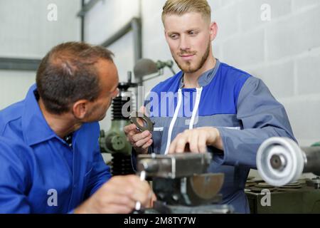 uomini che lavorano su un pezzo di metallo Foto Stock