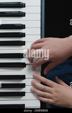 Scuola di musica. Il pianoforte suona due mani in exersizes. Tasti della tastiera del sintetizzatore in primo piano Foto Stock