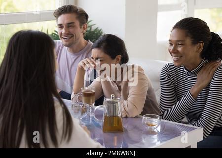 Amici felici multietnici che si godono il tempo libero nella caffetteria Foto Stock