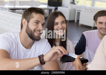 Felice giovane incontro con amici allegri in caffè Foto Stock