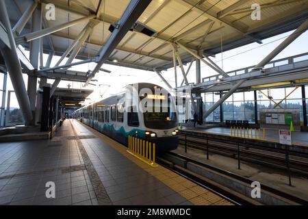 Un treno arriva quando il sole sorge alla stazione della metropolitana leggera Tukwila International Boulevard link di Tukwila, Washington. Foto Stock