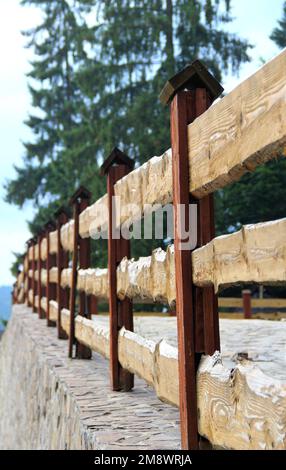 Wood Fence su Una fondazione di pietra per la storia verticale Foto Stock