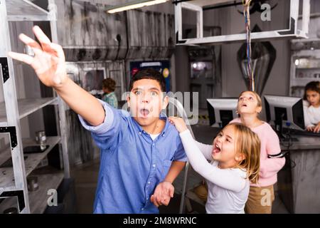 Bambina che urla al ragazzo per raggiungere qualcosa nella camera di ricerca bunker Foto Stock