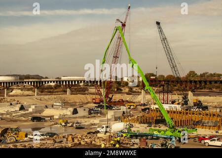 10-25-2022 Tulsa USA - Attrezzature per l'edilizia nel canale del fiume Arkansas costruzione di infrastrutture subacquee vicino a un ponte pedonale quasi completato Foto Stock