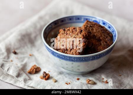 biscotti fatti in casa con ingredienti naturali, semi e granate, serviti in una ciotola blu Foto Stock